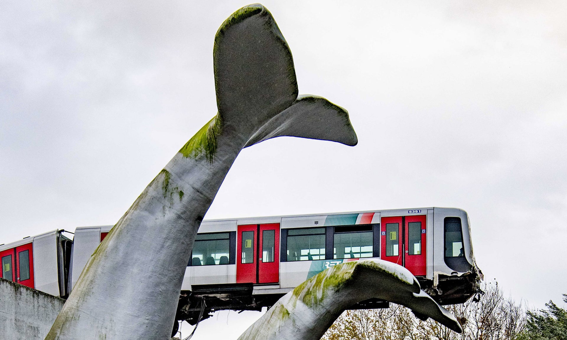 Rangkaian KRL Rotterdam Metro yang tersangkut di patung berbentuk ekor paus | Foto: EPA via The Guardian