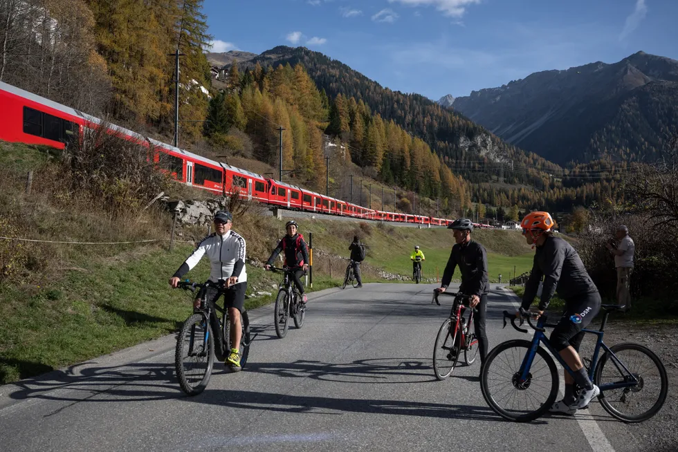 Pesepeda gunung dan balap melihat KRL 'Capricorn' 25SF4/ SF100 melintas di Bergun, Swiss | Foto: USA Today