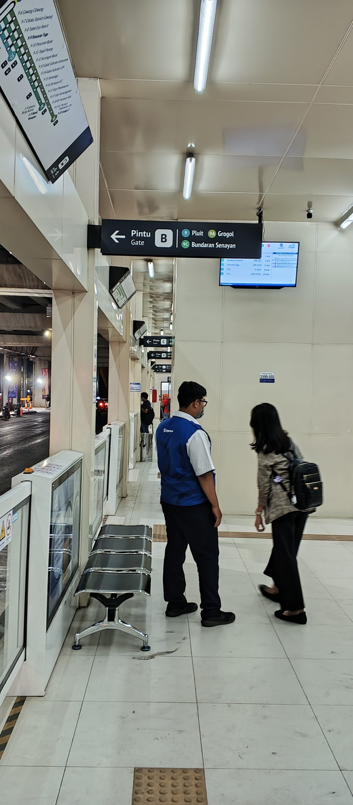 Seorang penumpang TransJakarta sedang bertanya kepada seorang Pramusapa Transjakarta. Kolom berukuran besar terlihat memenuhi peron halte sebelah selatan (arah barat) dan menyulitkan akses penumpang berjalan kaki | Foto: RED/Adrian Falah Diratama