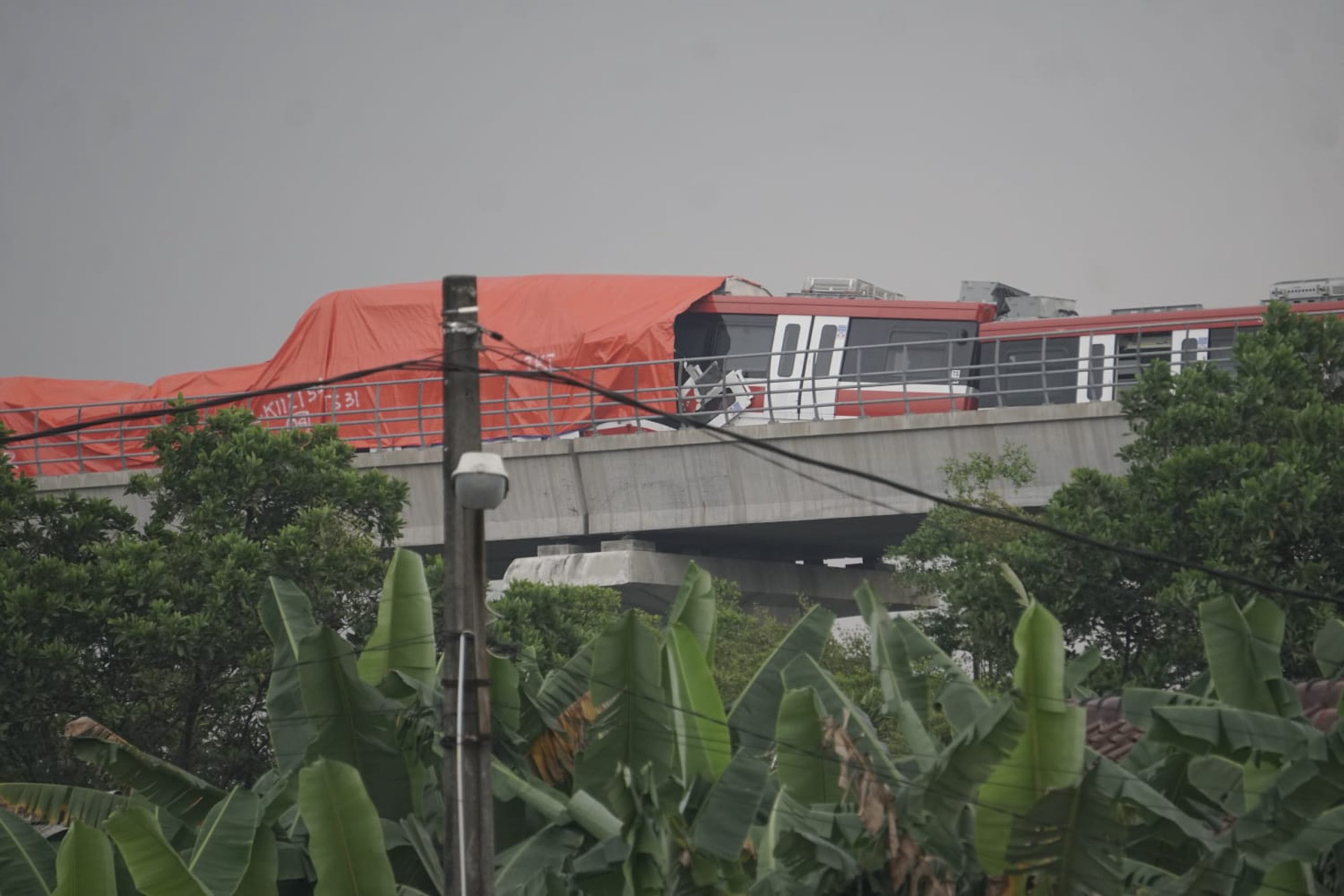 Petugas meninjau lokasi tabrakan LRT Jabodebek di Munjul, Jakarta Timur, Senin (25/10).