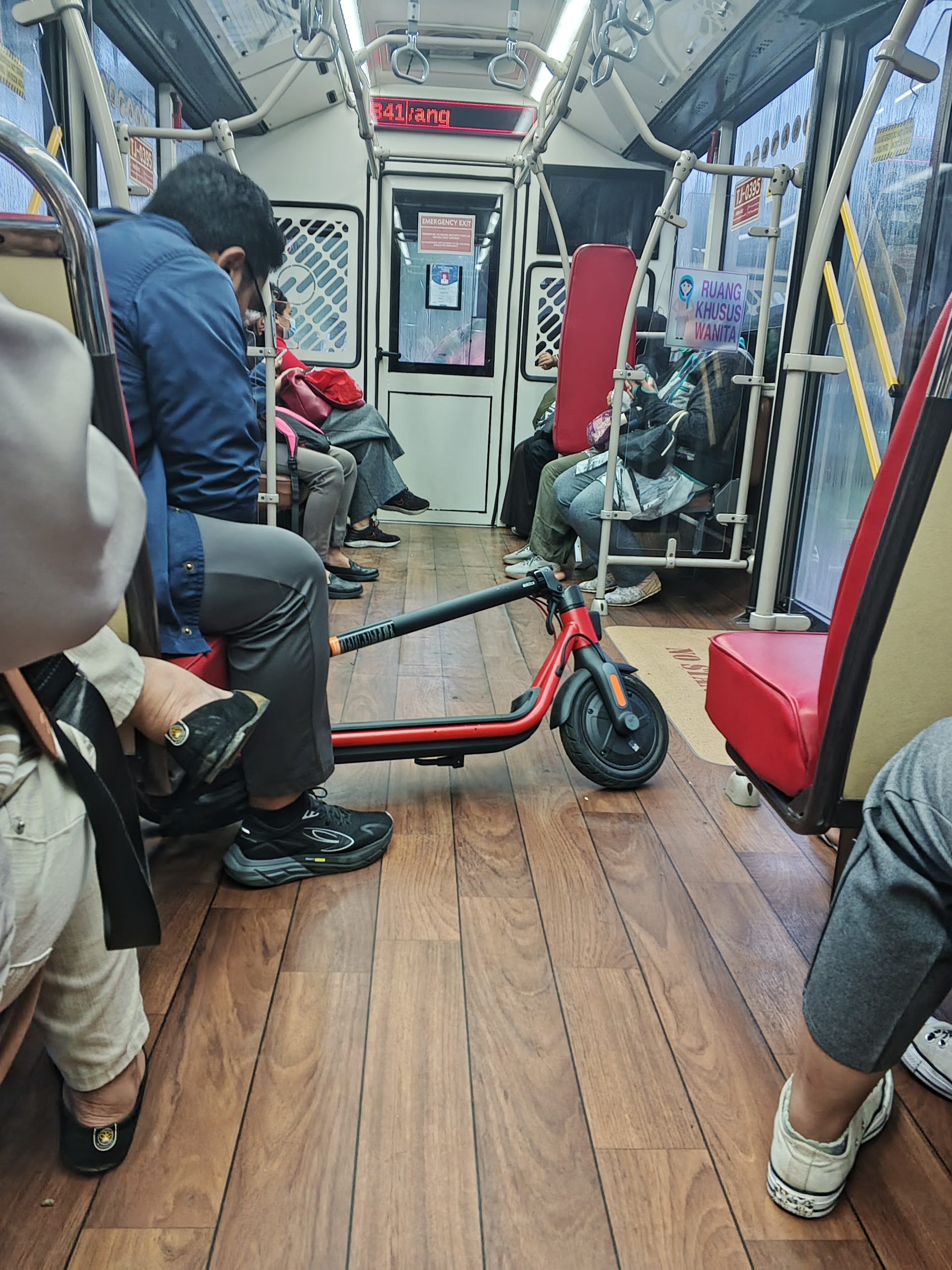 Penumpang membawa skuter lipatnya ke dalam bus | Foto: RED/ Adrian Falah Diratama